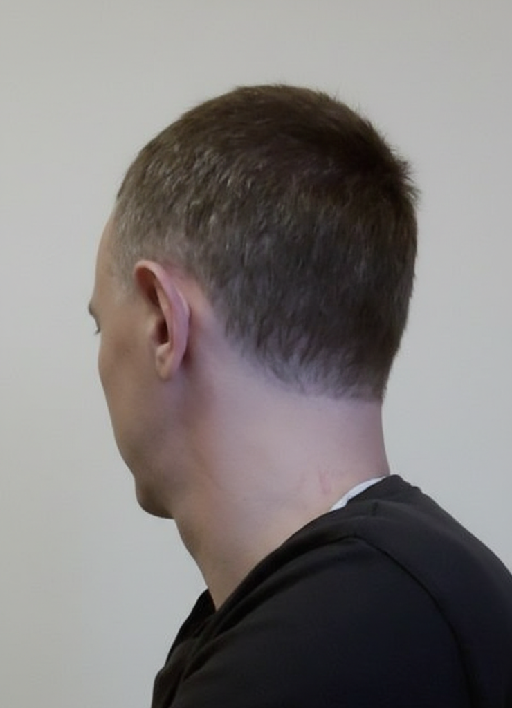 kamicane, der Mitgründer von Nawaland, schräg von hinten aufgenommen. kamicane ist ein Mann mit kurzen braunen Haaren. Er steht vor hellem Hintergrund, Kopf und Nacken sind sichtbar.